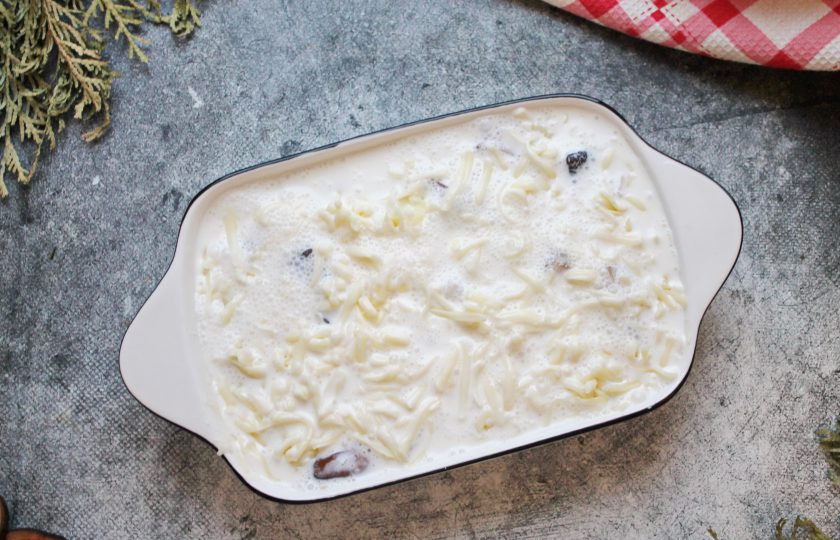 1. Этап. Индейка с белыми грибами: Сыр натрите на крупной или средней терке. Смешайте сыр со сметаной, водой, посолите и поперчите. Равномерно залейте верх грибов, чтобы заливка прошла до самого дна.