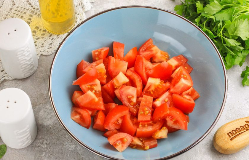 1. Этап. Салат с копченым сыром и помидорами: Нарежьте помидоры ломтиками или кубиками и высыпьте нарезку в глубокую емкость, салатник.