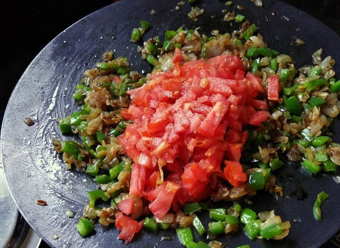 1. Этап. Закусочные булочки с овощами: 1. На раскаленной сковороде нагрейте растительное и сливочное масло. Поместите в сковороду измельченный лук. Обжарьте его до золотистости, после чего, добавьте к луку имбирь, чеснок, зеленый чили и помидоры. Протушите овощи в воде до мягкости.