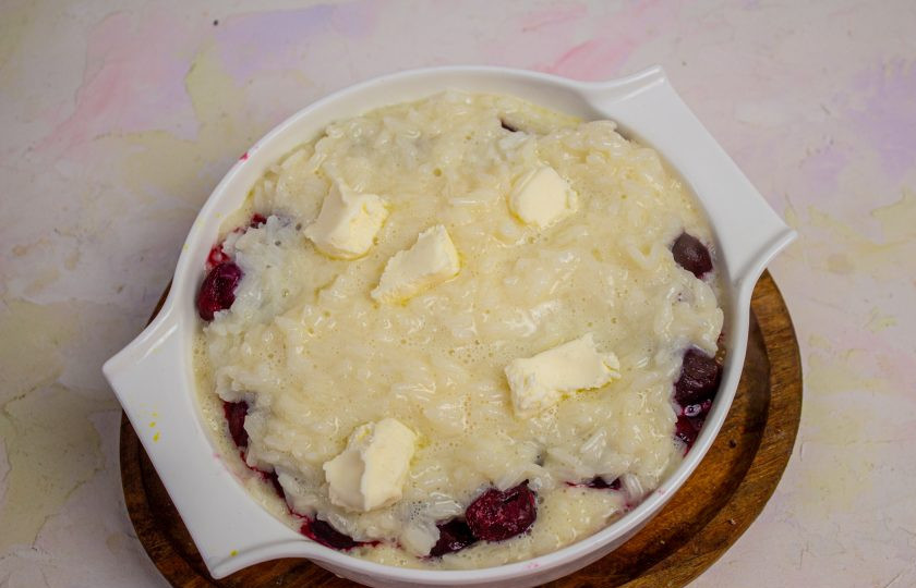 1. Этап. Рисовая запеканка с вишней: Поверх вишни снова выложите рисовую кашу и кусочки сливочного масла. Поставьте в заранее разогретую духовку до 180 градусов на 10-15 минут.