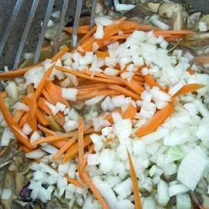 1. Этап. Пассерованный грибной суп: Когда грибной сок выпарится практически полностью, добавляем в кастрюлю две мелко нарезанные луковицы и одну соломкой нарезанную морковь.