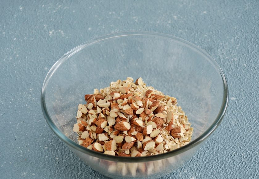 1. Этап. Запеченные мюсли с орехом: Добавьте в миску овсяные хлопья и орехи, хорошо перемешайте.