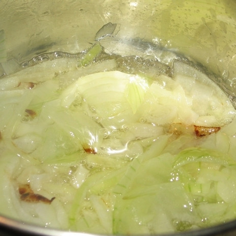 1. Этап. Сердце куриное: Лук очистить и нарезать на полукольца. В сотейнике разогреть масло, обжарить лук до мягкости (3-4 минуты на среднем огне).