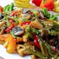 Теплый салат с курицей Куриное филе нарежьте небольшими кубиками и залейте соевым соусом, оставьте на 20 минут мариноваться. Затем обжарьте до готовности на растительном масле, в конце поперчите по вкусу, солить не нужно. Грибы нарежьте кубиками и обжарьте также на растительном масле до золотистости. Сладкий перец нарежьте соломкой и обжарьте вместе с фасолью в течении нескольких минут. Смешайте все овощи. На блюдо выложите листья салата, выложите салат и посыпьте кунжутом, подавайте пока теплый. Теплый салат с курицей и стручковой фасолью получается очень сытным, вкусным, ароматным и насыщенным. Готовить такой салат довольно просто, он отлично подойдет к любому праздничному столу, подавать можно как с гарниром так и как самостоятельное блюдо. Салат получается ярким и сочным, специи выбирайте по вашему вкусу, можете также добавить немного чеснока чтобы придать салату пикантности.
