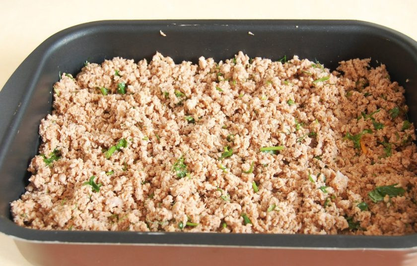 1. Этап. Мясная запеканка с гречкой: Фарш также обжарьте на сковороде. Добавьте к нему соль, перец, зелень, чеснок, томатную пасту и перемешайте. Выложите следующим слоем, поверх баклажан.