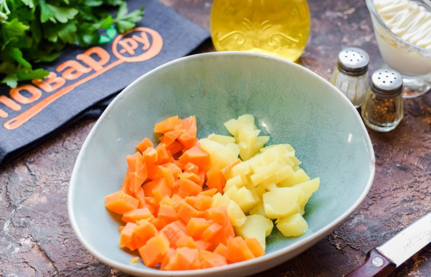 1. Этап. Салат Зимний с шампиньонами: Отварной картофель и морковь очистите, нарежьте кубиками и переложите в салатник.