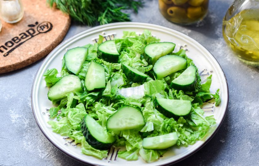 1. Этап. ПП салат из пекинской капусты: Свежие огурцы ополосните и просушите, нарежьте дольками. Выложите огурцы поверх пекинской капусты.