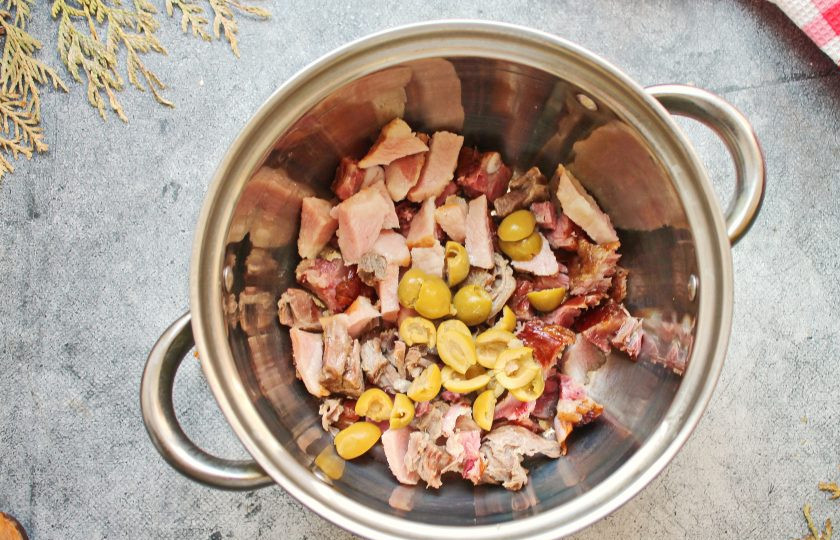 1. Этап. Солянка Московская: Достаньте из бульона готовое мясо, отделите его от костей и порежьте соломкой. Выложите в чистую кастрюлю и добавьте оливки. Их можно добавить целиком или разрезав пополам.