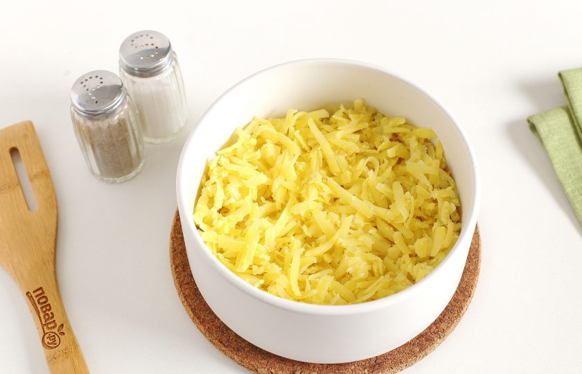 1. Этап. Салат из жареных шампиньонов: Каждый слой солите по вкусу и смазывайте майонезом (кроме слоя из обжаренных грибов). Первым слоем выложите тертый на крупной терке картофель.