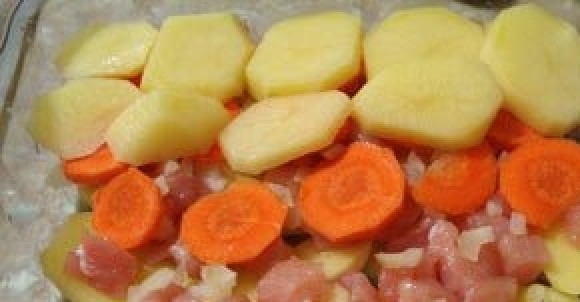 1. Этап. Картофельная запеканка с куриной грудкой: Форму для запекания смажьте маслом. Уложите в неё слой картофеля, потом курицу, лук, морковь и снова картофель. Каждый слой посолите.