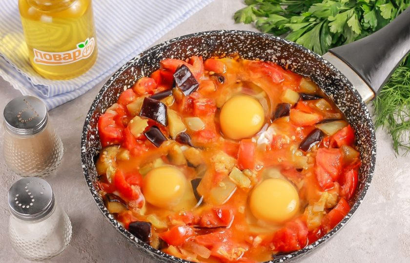 1. Этап. Шакшука с баклажанами и лимонной цедрой: Силиконовой лопаткой сделайте углубления в овощном соусе и аккуратно вбейте в них куриные яйца. Томите все примерно 5-7 минут.