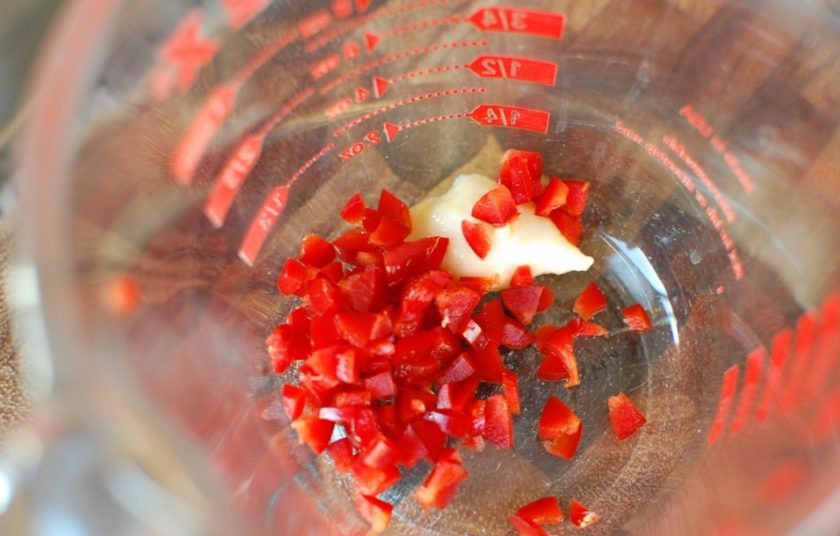 1. Этап. Куриные ножки в соусе Терияки: 1. Вымойте и разрежьте маленький перчик пополам, удалите семена и нарежьте его мелко. Смешайте его с измельченным чесноком.