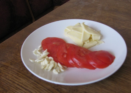 1. Этап. Мясо-гармошка в духовке: Нарезаем ломтиками помидоры, сыр и чеснок.