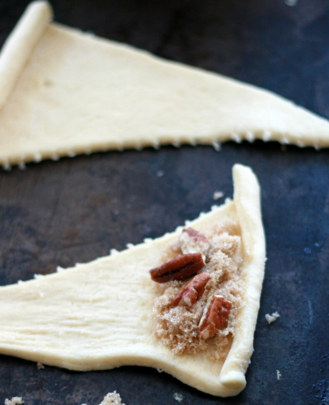 1. Этап. Рогалики с черносливом: В основании каждого треугольника выложите по чайной ложке коричневого сахара и несколько орешков.