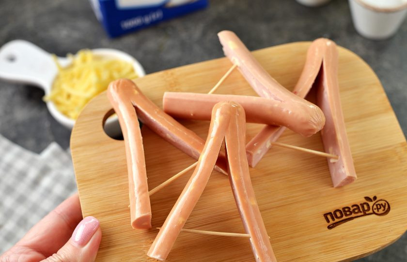 1. Этап. Звезды из сосисок и картофельного пюре: Сосиски разрежьте пополам, затем надрежьте каждую половинку, и вставьте зубочистку как показано на фото.