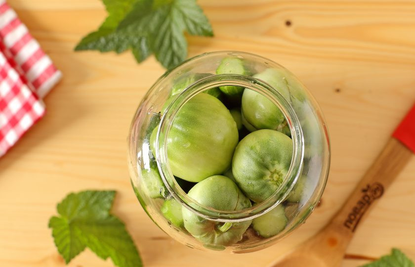 1. Этап. Огурцы с зелеными помидорами на зиму: Помидоры помойте и выложите сверху (сколько войдет).