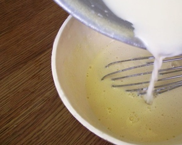 1. Этап. Домашнее мороженое из молока: Добавьте в молоко взбитые с сахаром желтки.