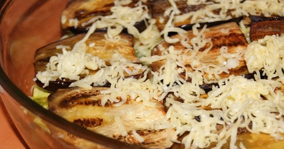 1. Этап. Мусака с картофелем: 5. Баклажаны посолить, затем промыть и обжарить на растительном масле. Выложить в форму и слегка присыпать сыром.