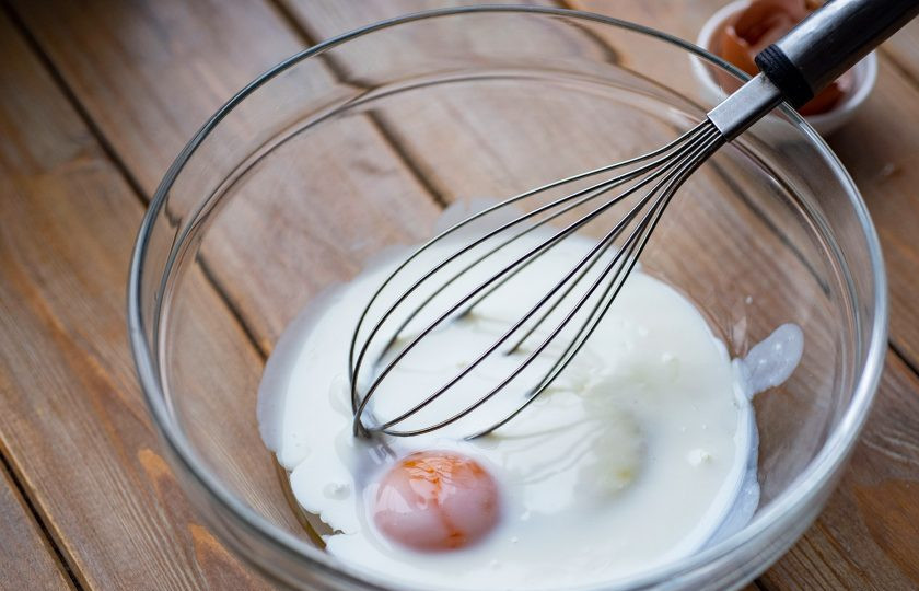 1. Этап. Вареники на кефире и дрожжах: Сначала займитесь тестом. В просторную миску вбейте яйцо, залейте кефир, добавьте соль. Активно перемешайте эти ингредиенты венчиком до получения однородной смеси.