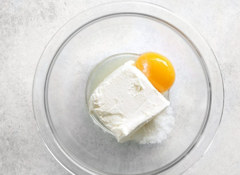 1. Этап. Галета с черникой и сливочным сыром: 5. В другую миску выложите сливочный сыр, куриный желток, оставшийся сахар, 1 чайную ложку лимонного сока.