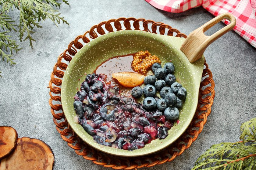 1. Этап. Соус из голубики к мясу: Половину ягод разомните и выложите в сковороду. Добавьте мед, соус, горчицу, посолите и поперчите. Выложите оставшиеся ягоды голубики.