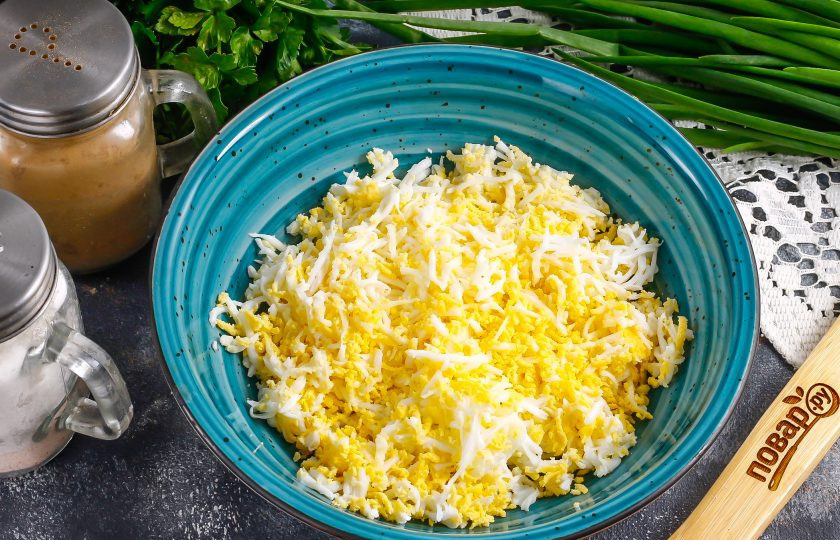 1. Этап. Паштет из копченой рыбы: Очистите остывшие отварные куриные яйца от скорлупы, промойте их в воде и натрите на терке с мелкими ячейками в глубокую емкость.