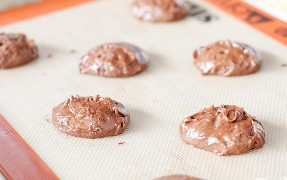 1. Этап. Печенье с зефирной начинкой и шоколадной глазурью: 2. Выложить по 1 столовой ложки теста на расстоянии около 7 см друг от друга на подготовленные противни и запекать в течение 10 минут. Дать остыть на противне в течение 2 минут, затем дать полностью остыть на стойке.