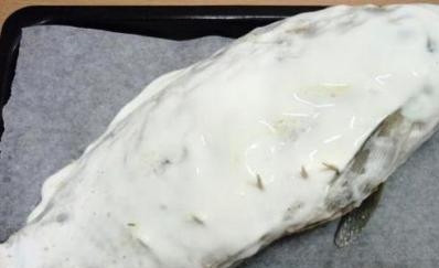 1. Этап. Карп с шампиньонами: Выкладываем рыбу на противень, застеленный бумагой, и смазываем сметаной. Дальше отправляем его в горячую духовку на 50 минут при температуре в 180 градусов.