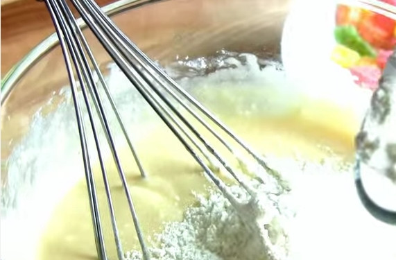 1. Этап. Маффины с цукатами в формочках: 3. Просейте муку с разрыхлителем и ванильным сахаром. Отправьте в яичную смесь и перемешайте тесто венчиком. Оно должно получиться не очень густым.