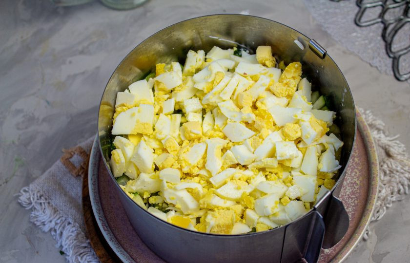 1. Этап. Салат с копченой курицей, черносливом и грецкими орехами: Отварные яйца нарежьте кубиком, выложите плотно на свежий огурец.