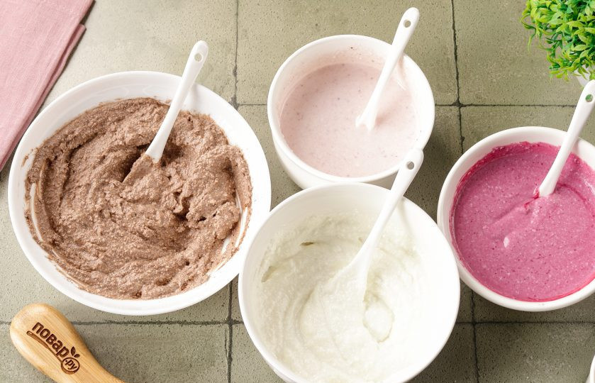 1. Этап. Десерт с желатином и творогом: Разделите творожную массу на 4 части. В одну часть добавьте ванилин, в другую какао, в третью клубничное пюре, в четвертую — пюре из черной смородины. Желатин распустите на медленном огне или в микроволновке до полного растворения. Но не кипятите. Горячий желатин также разделите на 4 равные части. При быстром и постоянно помешивании тонкой струйкой влейте каждую часть желатина в сметанную массу.