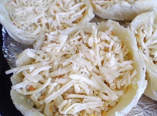 1. Этап. Слойки с рыбой: Наполняем наши корзиночки рыбной начинкой, посыпаем тертым сыром и отправляем в духовку допекаться минут на 15.