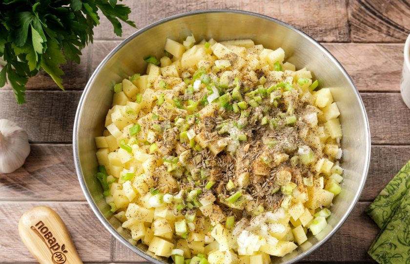 1. Этап. Эчпочмак без дрожжей: Картофель нарежьте кубиками чуть поменьше, а лук желательно нарезать максимально мелко, насколько это возможно. Зелёный лук промойте, обсушите и так же порубите ножом. Добавьте к начинке 1 ст.л. растительного масла, соль, молотый чёрный перец и любимые специи по вкусу.