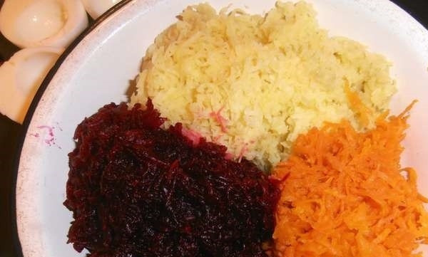 1. Этап. Закуска Селедка под шубой в яйце: Вареные овощи потрите на мелкой терке. Традиционно их трут на крупную терку, но следует помнить, что мы готовим маленькую версию этого салата. Овощи смешайте с желтками и майонезом. Мелко порежьте лук, перемешайте его с начинкой. Приправите ее по вкусу.