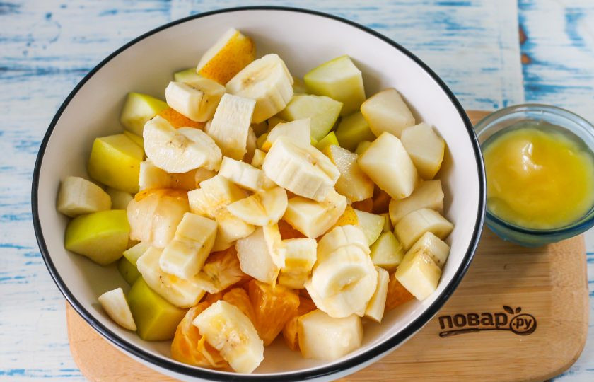 1. Этап. Фруктовый салат с йогуртом для детей: Точно так же как и с яблоком, поступите с грушей, удаляя семена и нарезая кубиками. Банан очистите от кожуры, нарежьте полукольцами и добавьте обе нарезки в емкость.