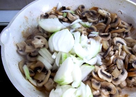 1. Этап. Отбивные из телятины в духовке: Репчатый лук чистим и нарезаем перьями, выкладываем его на сковороду к грибам и жарим все до мягкости лука, немного солим и перчим грибы с луком.