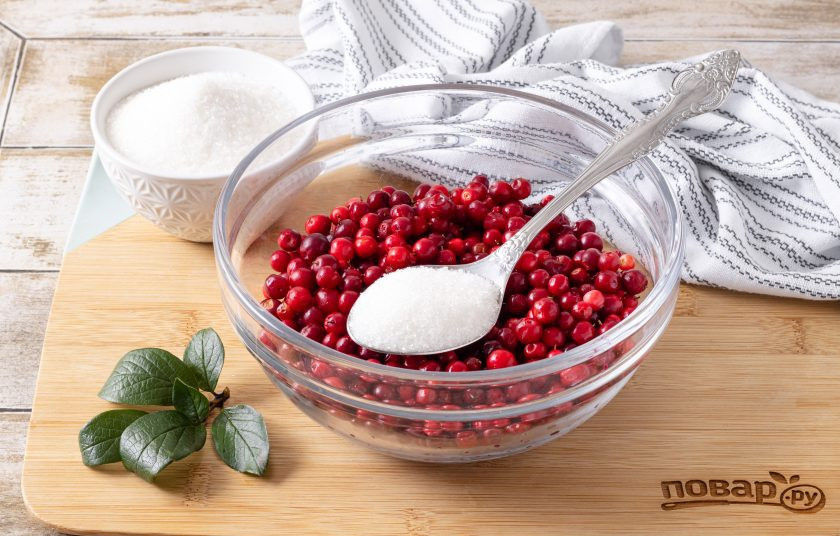 1. Этап. Сушеная брусника: Бруснику помойте и переберите. Используйте только целые неиспорченные ягоды. Засыпьте ягоды сахаром, перемешайте и оставьте на несколько часов, чтобы они дали сок.