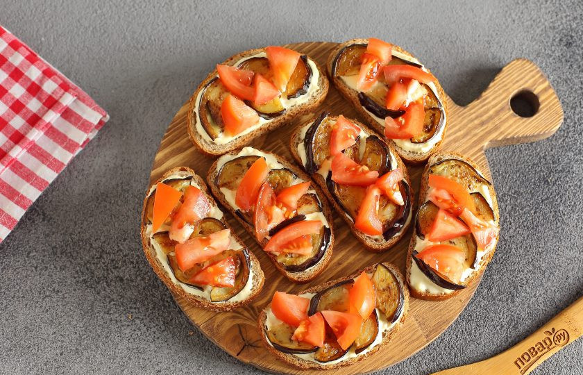 1. Этап. Бутерброды с баклажанами и помидором: Сверху выложите обжаренные баклажаны и нарезанный помидор.