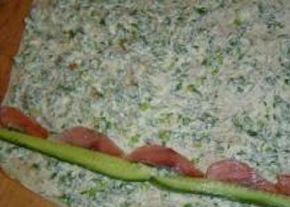 1. Этап. Рулет из лаваша с горбушей: 3. Огурцы и перец вымыть и обсушить. Огурец нарезать тонкими полосками. Из перца удалить сердцевину и нарезать тонкой соломкой. Наверх лаваша выложить полоски огурца на всю длину лаваша и рядом положить кусочки горбуши. Валиком завернуть огурцы и кусочки лаваша в один оборот.