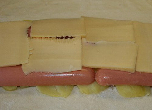 1. Этап. Пирог с сосиской и картошкой: Нарезаем тонкими ломтиками сыр, укладываем на сосиски.