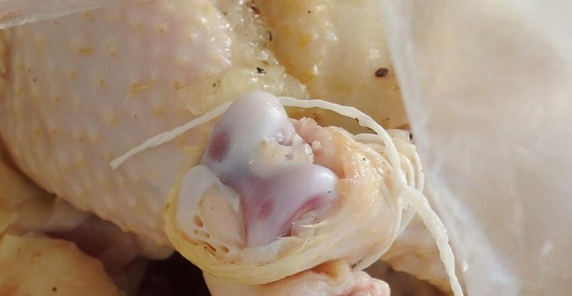 1. Этап. Рецепт запеченной курицы с картофелем: Курицу промойте, очистите, свяжите ножки и натрите маринадом. Уберите курицу в рукав для запекания.