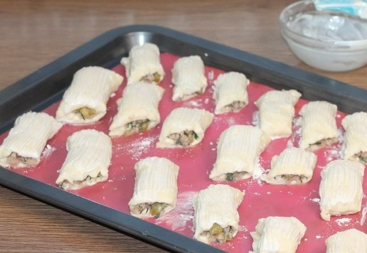 1. Этап. Мини-слойки с тунцом и оливками: 14. Застелите противень пергаментом или силиконом и выложите заготовки. Смажьте заготовки жидкой сметаной. Сметану предварительно смешайте с 1 ч. л. растительного масла. Оставьте заготовки в теплом месте, минут на 20 или до увеличения в 2 раза.