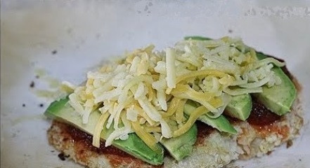 1. Этап. Курица с авокадо под сырной шубкой: Сыр натрите на крупной терке, и посыпьте им каждый кусочек курицы.