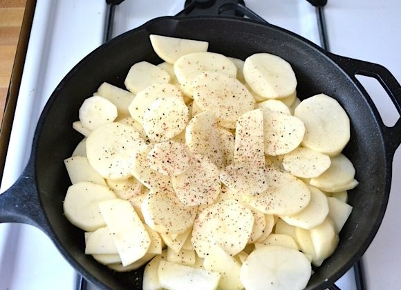 1. Этап. Фриттата с ветчиной и картофелем: 1. Почистите картофель и нарежьте тонкими дольками. Разогрейте сковороду, которую можно будет использовать и в духовке с оливковым маслом, выложите в нее картофель, посолите, поперчите и готовьте в течение 10 минут, периодически помешивая.