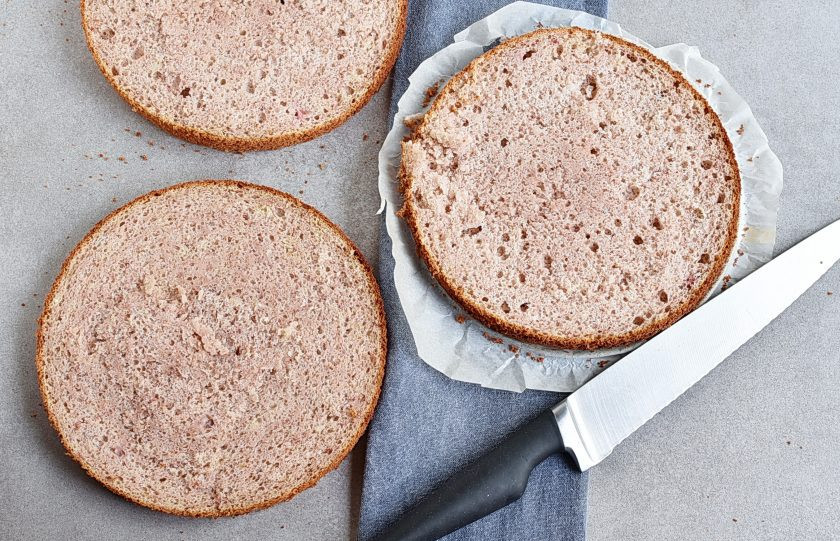 1. Этап. Клубничный торт с шоколадным кремом и глазурью: Готовый корж достаньте из духовки и через 5 минут извлеките из формы на решетку. Дайте полностью остыть. Лучше дать бисквиту отлежаться ночь под пленкой. Если спешите, разрезайте остывший корж на три пласта. Коржи в пропитке не нуждаются, они мягкие и сочные. Но при желании можно немного сбрызнуть их клубничным сиропом.