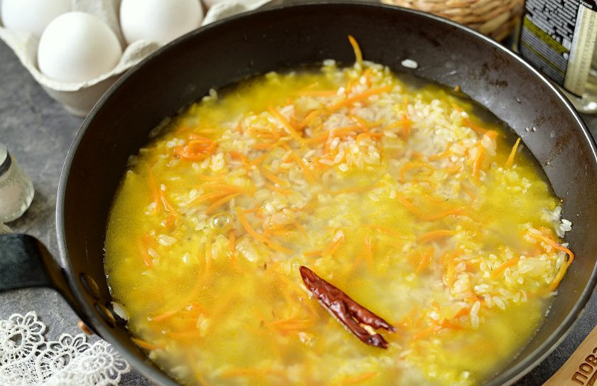 1. Этап. Плов на льняном масле с яйцами: Влейте теплой воды из чайника, она должна слегка покрывать рис с овощами. Доведите до кипения, посолите, прикройте крышкой и готовьте на тихом огне 17-20 минут. Спустя время выключите плиту, а плов оставьте под крышкой еще минут на 15.