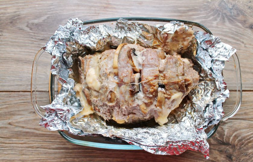 1. Этап. Мясная гармошка с сыром и грибами: Выложите мясо в фольге в форму для запекания, налив на дно немного воды. Поставьте в горячую духовку и запекайте при температуре 180 градусов в течение одного часа.