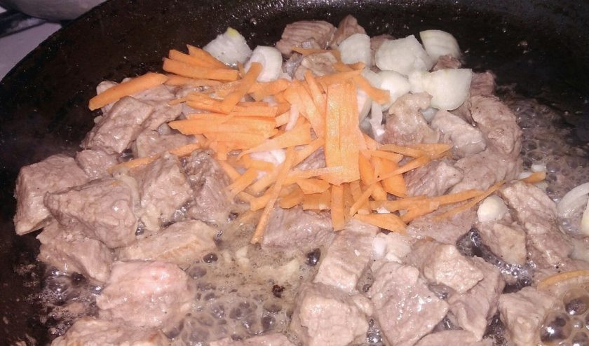 1. Этап. Жаркое с говядиной и овощами на растительном масле: 2. Добавляем лук и морковь, а также солим и приправляем по вкусу. В этот момент можно добавить измельченный чеснок.