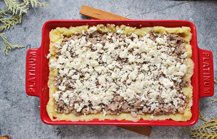 1. Этап. Аши по-гречески: Поверх мяса раскрошите 2/3 брынзы.