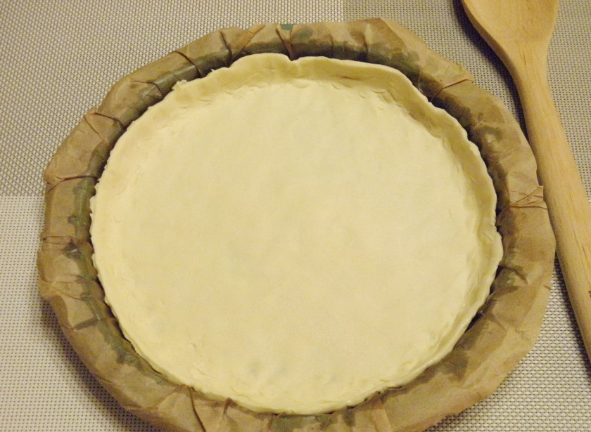 1. Этап. Пирог с гречкой и печенью: Возьмите невысокую форму. Застелите её бумагой и смажьте растительным маслом без запаха. Тесто пальцами разровняйте по форме, формируя бортики.